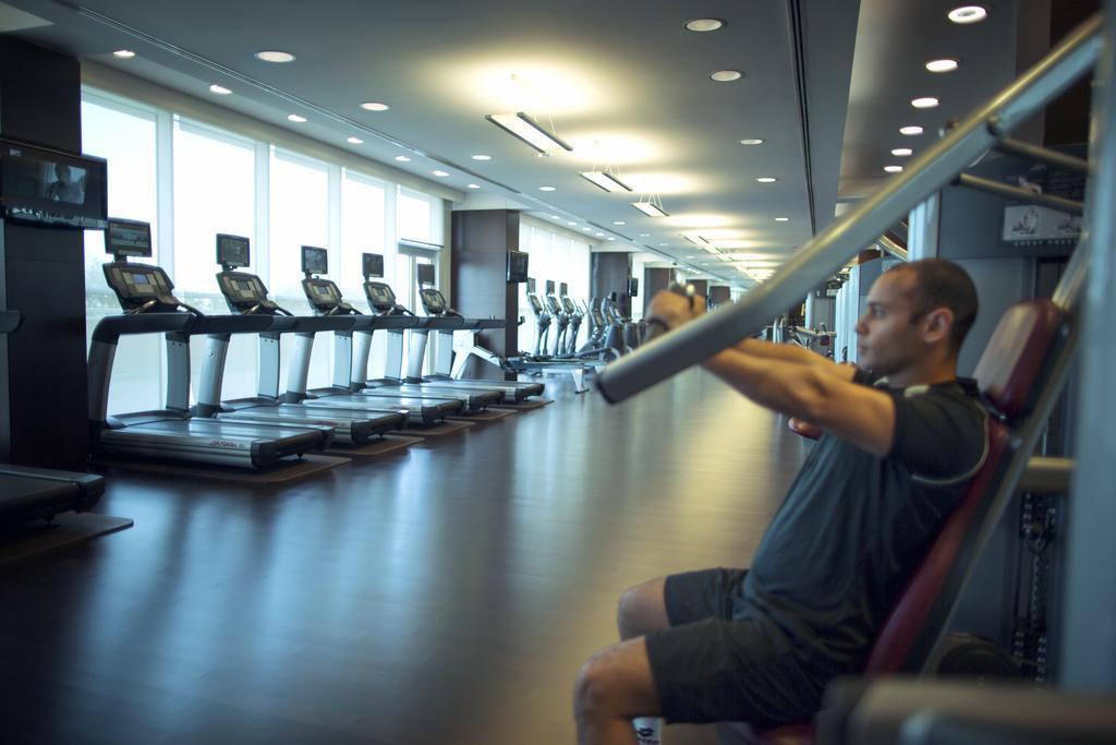 Hyatt Regency Oryx Doha Hotel Exterior photo A man using a lat pulldown machine