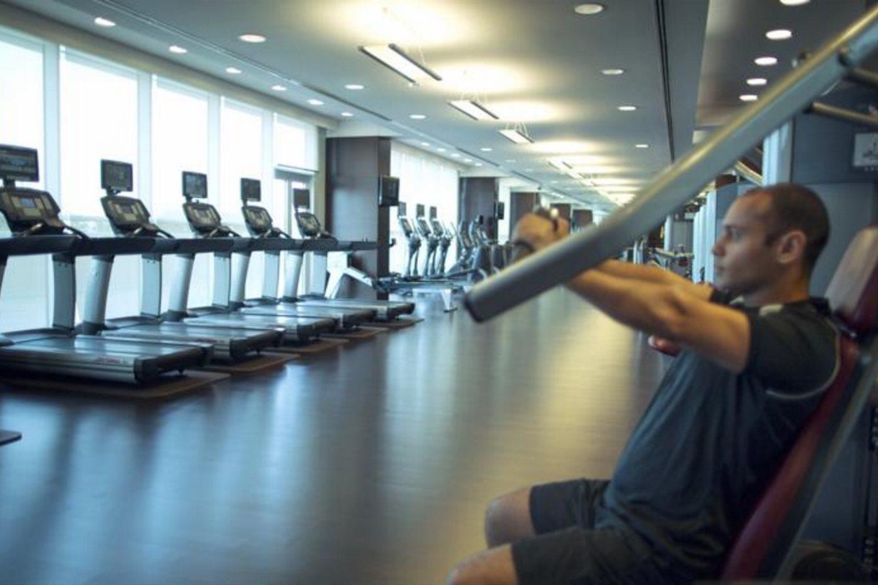 Hyatt Regency Oryx Doha Hotel Exterior photo A man using a lat pulldown machine